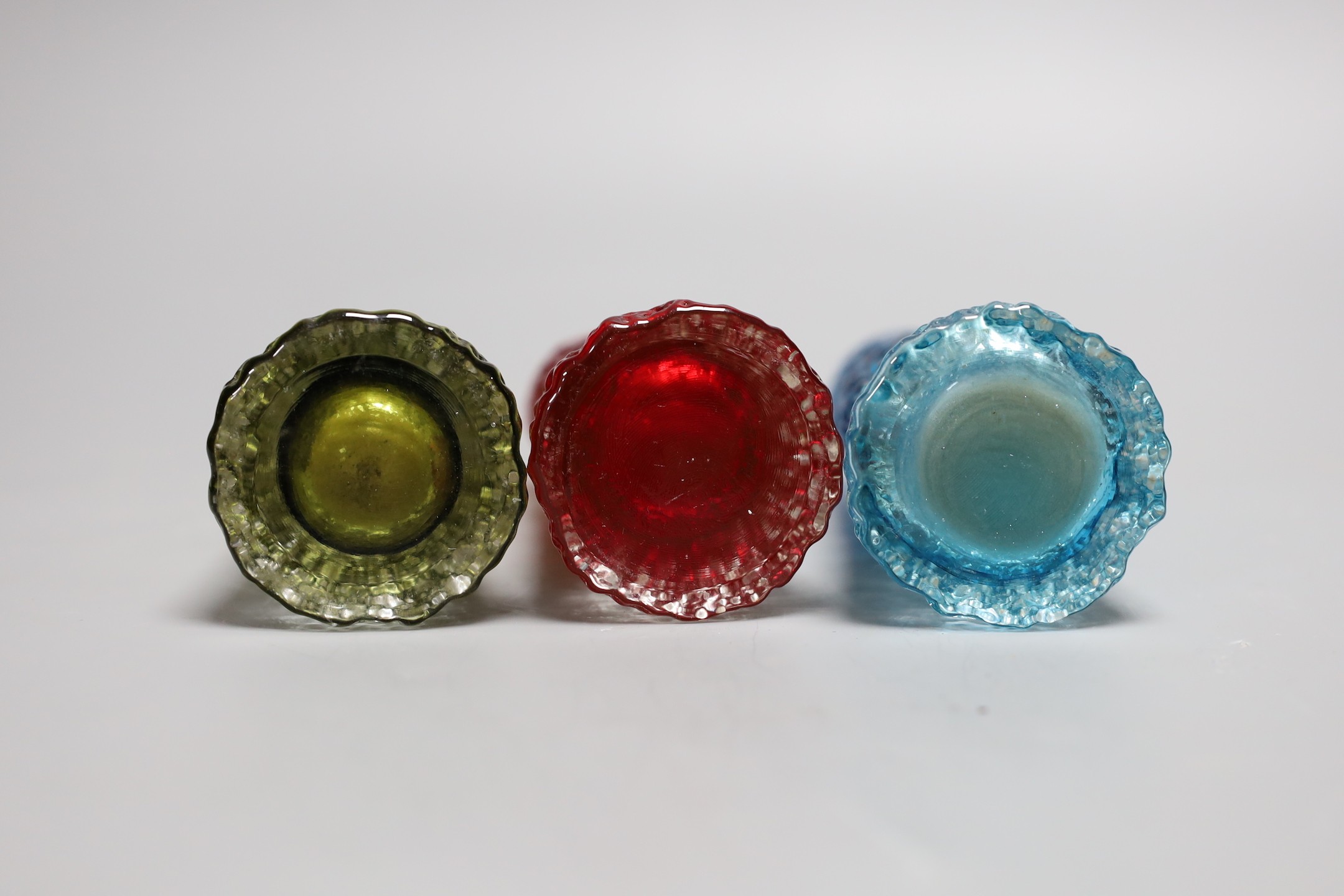 A trio of tapering 'bark' Whitefriar vases, model 9729 designed by Geoffrey Baxter, in red, kingfisher blue and sage green glass, each 16cm high.